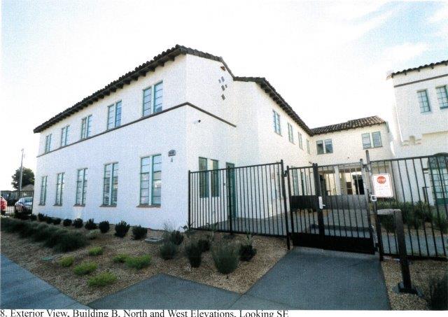 After: View of gated landscaped courtyard, school, and elevated breezeway connecting to the offices.